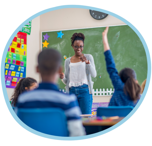 Teacher standing at the front of a classroom with students attentively listening and participating.